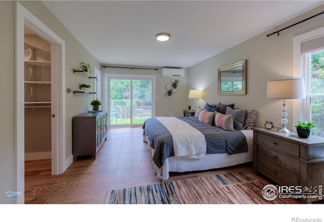 419 Centennial Dr, Louisville, CO 80027 - bedroom featuring a wall mounted air conditioner, light wood finished floors, access to outside, and a spacious closet
