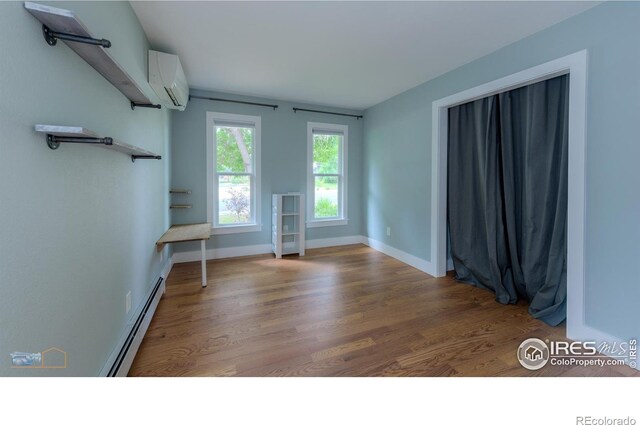 419 Centennial Dr, Louisville, CO 80027 - unfurnished room with a baseboard heating unit, wood finished floors, and a wall unit AC