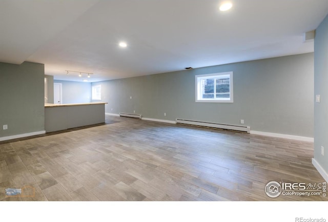 419 Centennial Dr, Louisville, CO 80027 - empty room with baseboard heating, a baseboard radiator, wood finished floors, recessed lighting, and rail lighting