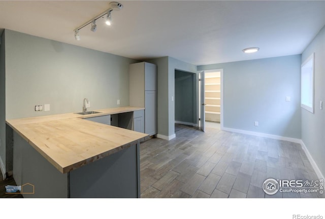 419 Centennial Dr, Louisville, CO 80027 - kitchen featuring wooden counters, wood finished floors, a peninsula, and rail lighting