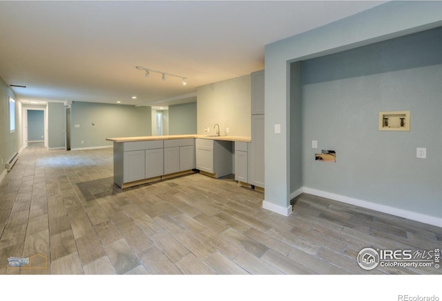 419 Centennial Dr, Louisville, CO 80027 - kitchen with a peninsula, light wood-type flooring, a baseboard heating unit, light countertops, and open floor plan