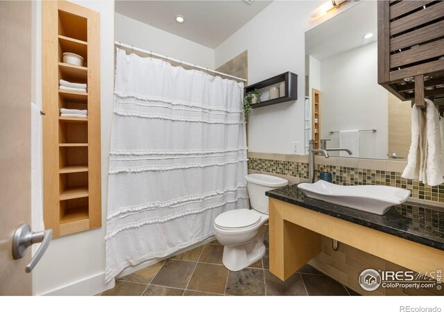 1260 Claremont Dr, Boulder, CO 80305 - full bath featuring vanity, curtained shower, backsplash, and tile patterned floors