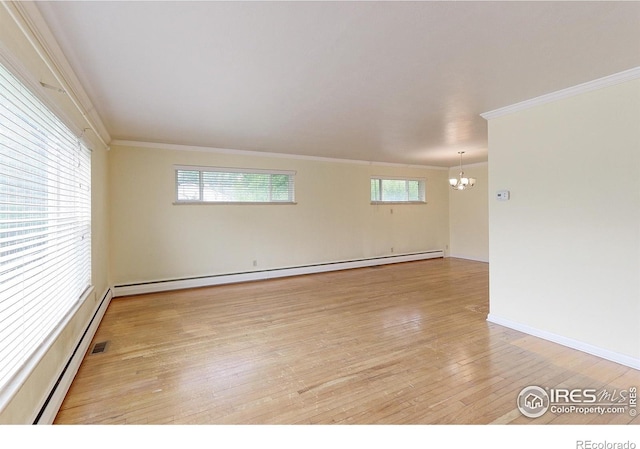 353 S Niagara St, Denver, CO 80224 - spare room featuring a baseboard heating unit, a chandelier, ornamental molding, and light wood-type flooring