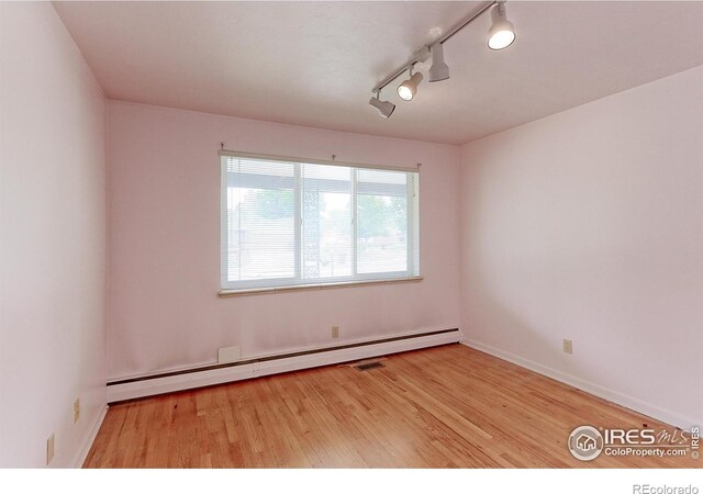 353 S Niagara St, Denver, CO 80224 - unfurnished room with baseboard heating, wood finished floors, and track lighting