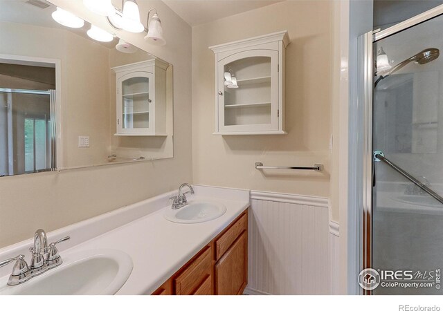 353 S Niagara St, Denver, CO 80224 - full bath with a stall shower, double vanity, and wainscoting