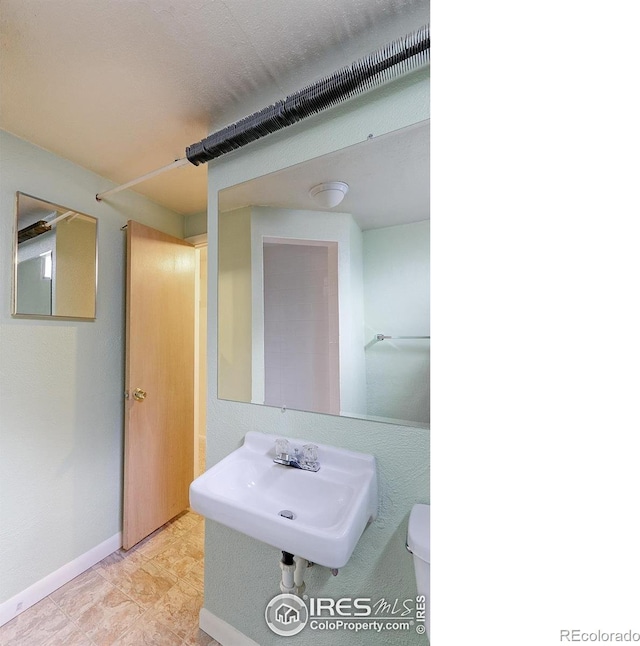 353 S Niagara St, Denver, CO 80224 - half bathroom featuring a sink and baseboards