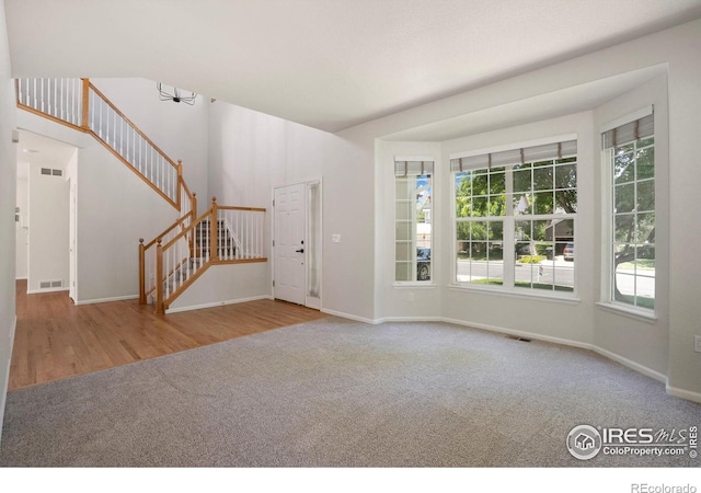 10216 Sandy Ridge Ct, Firestone, CO 80504 - unfurnished living room featuring carpet floors, plenty of natural light, and stairway