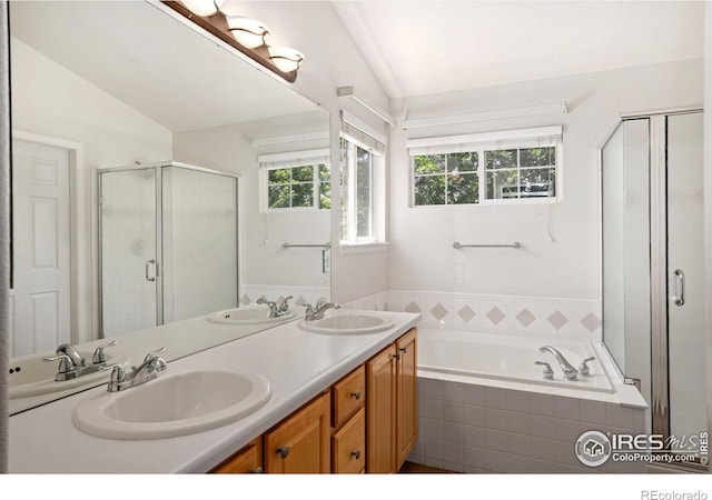 10216 Sandy Ridge Ct, Firestone, CO 80504 - bathroom featuring lofted ceiling, double vanity, a shower stall, and a garden tub