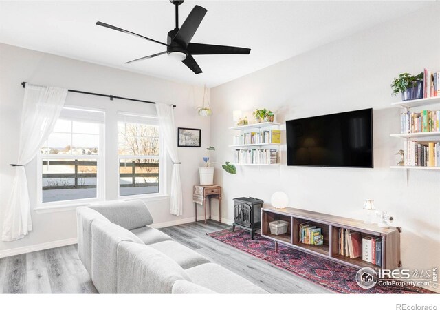 897 Winding Brook Dr, Berthoud, CO 80513 - living area with wood finished floors, a wood stove, and a ceiling fan