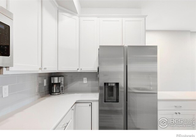 897 Winding Brook Dr, Berthoud, CO 80513 - kitchen with stainless steel fridge, white cabinets, decorative backsplash, and light countertops
