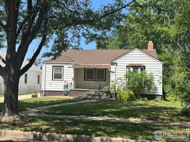 305 Euclid St, Fort Morgan, CO 80701 - view of front of house with a chimney, a front yard, and roof with shingles