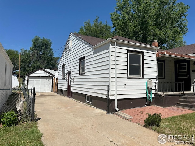 305 Euclid St, Fort Morgan, CO 80701 - view of front facade with a garage, an outdoor structure, driveway, and covered porch