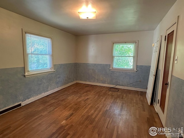 305 Euclid St, Fort Morgan, CO 80701 - unfurnished room featuring wood finished floors and a wainscoted wall