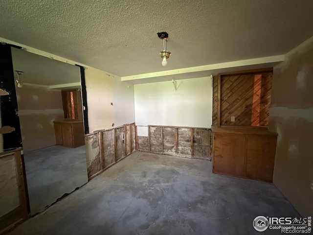 305 Euclid St, Fort Morgan, CO 80701 - spare room featuring unfinished concrete floors and a textured ceiling