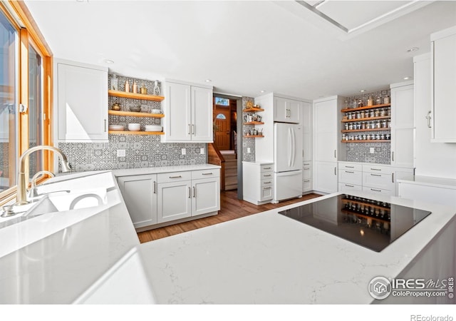 311 Sky Trail Rd, Boulder, CO 80302 - kitchen with open shelves, black electric stovetop, freestanding refrigerator, light stone counters, and recessed lighting