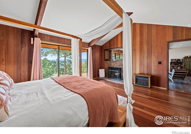 311 Sky Trail Rd, Boulder, CO 80302 - bedroom featuring wood walls, a fireplace with raised hearth, wood finished floors, and access to outside