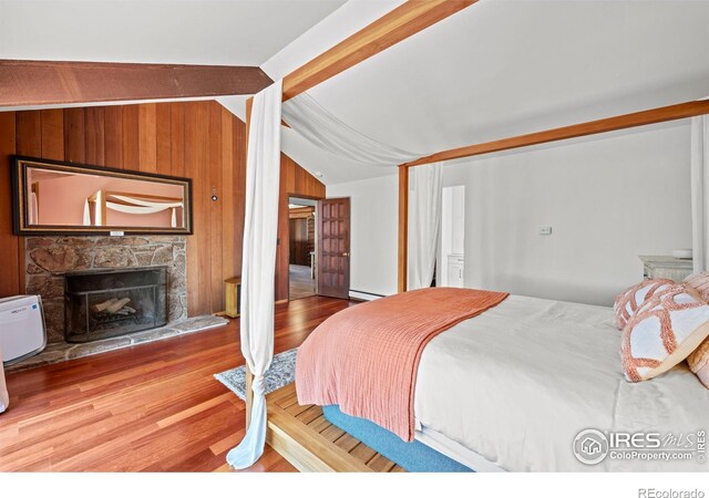 311 Sky Trail Rd, Boulder, CO 80302 - bedroom featuring wood finished floors, a fireplace, wooden walls, and a baseboard radiator
