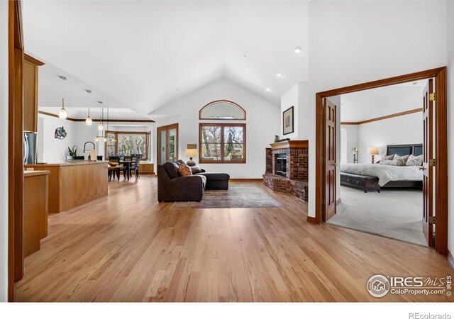 5986 Heather Way, Longmont, CO 80503 - living area with light wood-type flooring, a fireplace, and high vaulted ceiling