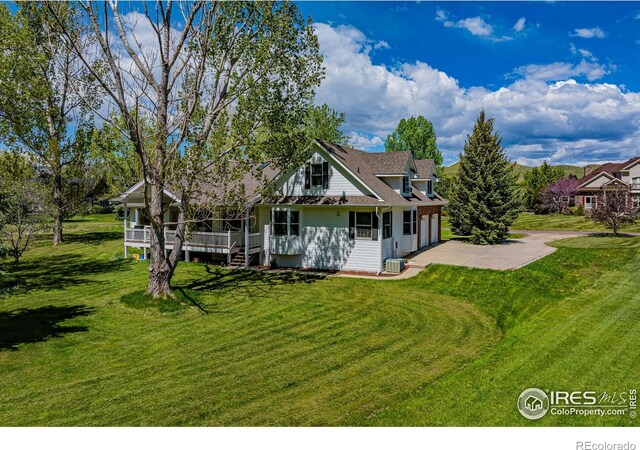 5986 Heather Way, Longmont, CO 80503 - back of house with a garage, a lawn, and driveway
