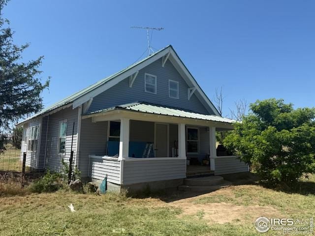 22400 County Road 40, Wray, CO 80758 - rear view of house with a sunroom, a metal roof, and a lawn