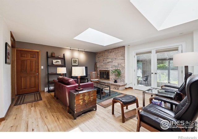 7290 Mount Sherman Rd, Longmont, CO 80503 - living room with a skylight, light wood-type flooring, french doors, track lighting, and a fireplace