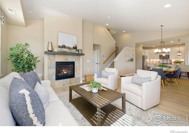 2599 Trio Falls Dr, Loveland, CO 80538 - living area featuring light wood-type flooring, stairs, lofted ceiling, recessed lighting, and a fireplace