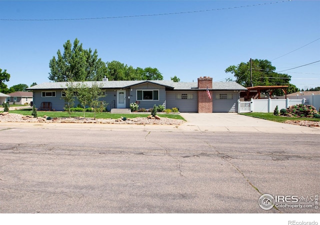 947 Holden Ln, Sterling, CO 80751 - ranch-style house featuring a chimney, concrete driveway, and an attached garage