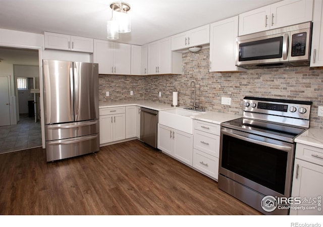 947 Holden Ln, Sterling, CO 80751 - kitchen featuring appliances with stainless steel finishes, light countertops, white cabinetry, and backsplash
