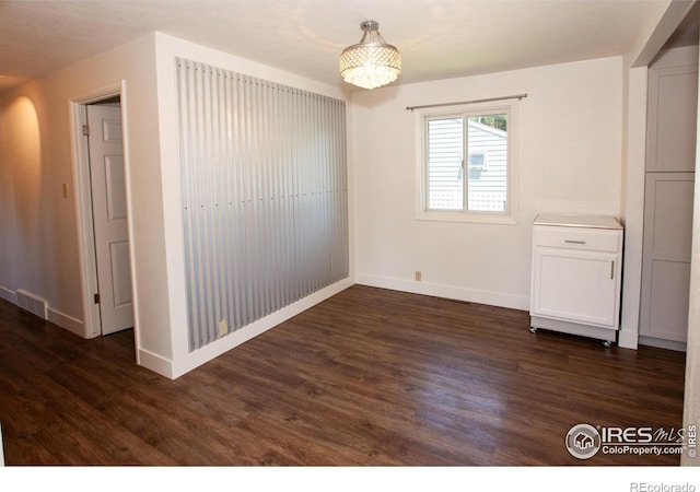 947 Holden Ln, Sterling, CO 80751 - unfurnished room featuring dark wood-style floors and a chandelier