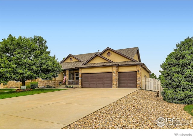 9629 Bountiful St, Firestone, CO 80504 - view of front of home with an attached garage, concrete driveway, stone siding, and a shingled roof