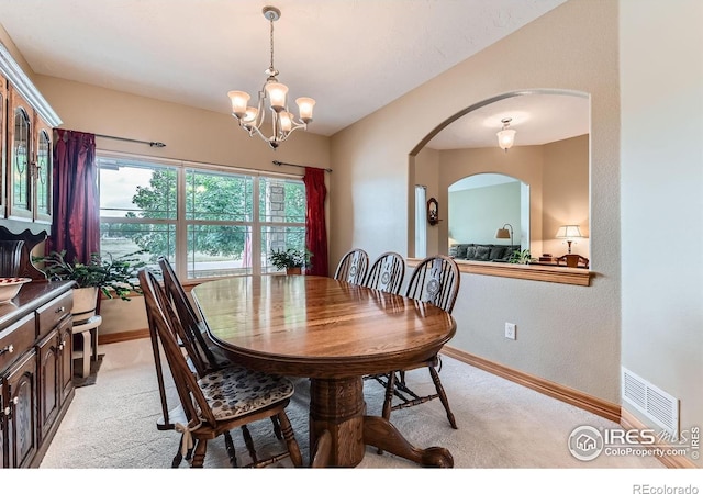 9629 Bountiful St, Firestone, CO 80504 - dining area featuring light carpet, a chandelier, and arched walkways