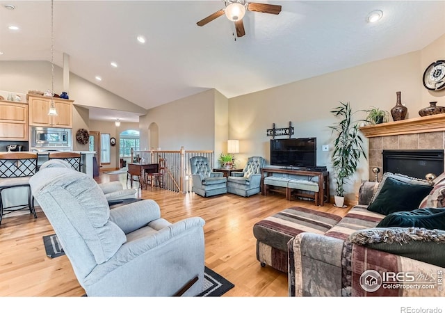 9629 Bountiful St, Firestone, CO 80504 - living room featuring arched walkways, a ceiling fan, a tile fireplace, light wood-style floors, and recessed lighting