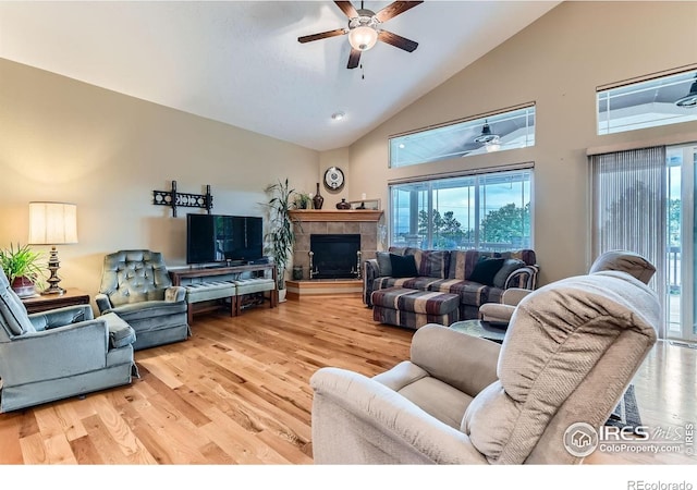 9629 Bountiful St, Firestone, CO 80504 - living area featuring ceiling fan, high vaulted ceiling, plenty of natural light, light wood-type flooring, and a tile fireplace