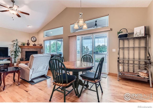 9629 Bountiful St, Firestone, CO 80504 - dining space with light wood finished floors, a tile fireplace, a ceiling fan, and high vaulted ceiling