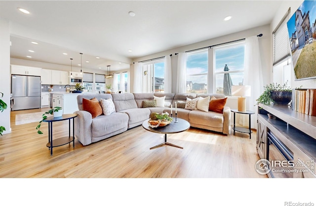 6013 Goodnight Ave, Timnath, CO 80547 - living room with light wood finished floors and recessed lighting