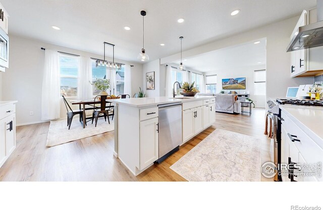 6013 Goodnight Ave, Timnath, CO 80547 - kitchen with range with gas cooktop, dishwasher, wall chimney exhaust hood, light wood finished floors, and plenty of natural light
