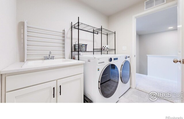 6013 Goodnight Ave, Timnath, CO 80547 - laundry area featuring washing machine and clothes dryer, light tile patterned flooring, and light colored carpet