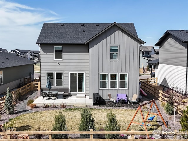 6013 Goodnight Ave, Timnath, CO 80547 - back of property with board and batten siding, a playground, a patio, and a fenced backyard
