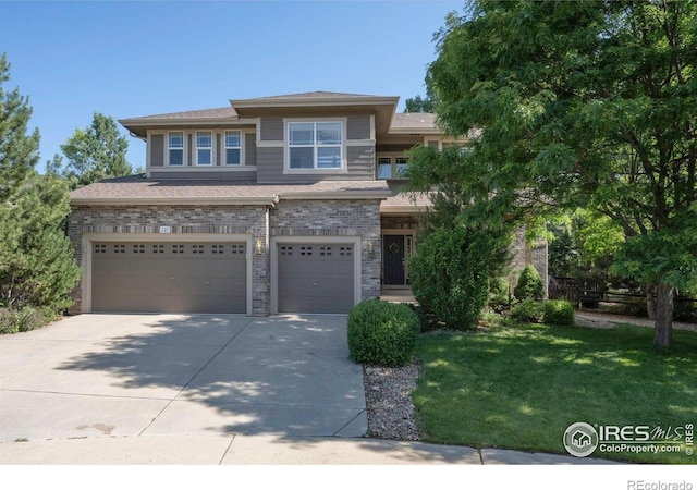 121 Osprey Ln, Lyons, CO 80540 - view of front facade featuring a garage, driveway, a front yard, and brick siding
