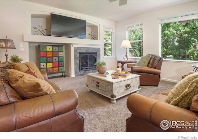 121 Osprey Ln, Lyons, CO 80540 - carpeted living room featuring a tiled fireplace and a ceiling fan
