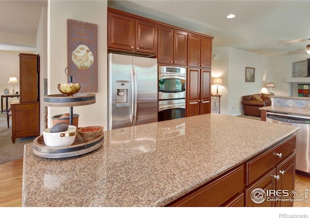 121 Osprey Ln, Lyons, CO 80540 - kitchen with appliances with stainless steel finishes, open floor plan, light wood-style floors, a ceiling fan, and recessed lighting