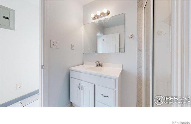 595 E Kiser Ave, Keenesburg, CO 80643 - full bath with electric panel, vanity, tile patterned flooring, and a shower with shower door