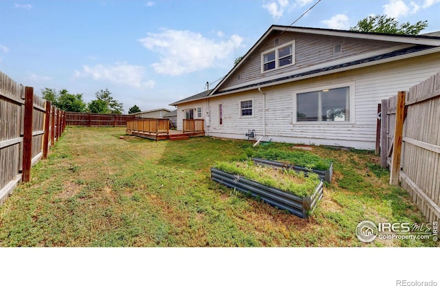 595 E Kiser Ave, Keenesburg, CO 80643 - rear view of house featuring a deck, a fenced backyard, and a vegetable garden