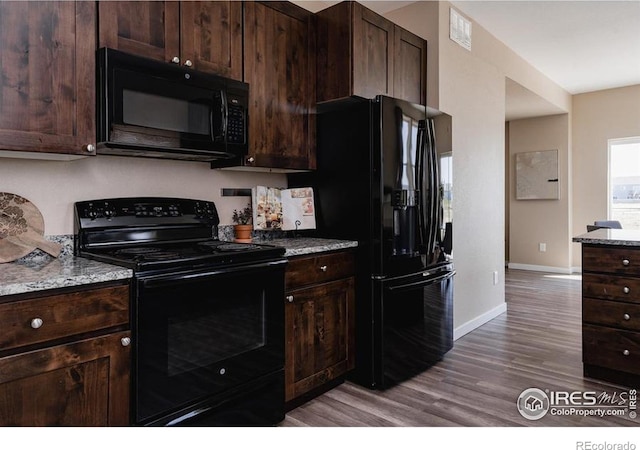 184 S 2nd Ave, Deer Trail, CO 80105 - kitchen featuring black appliances, wood finished floors, dark brown cabinetry, and light stone countertops