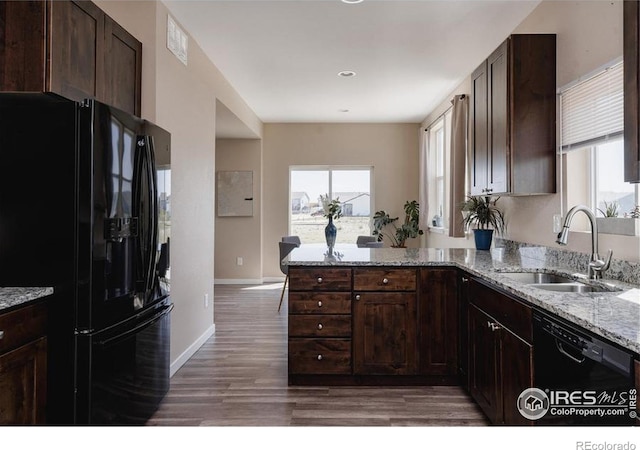 184 S 2nd Ave, Deer Trail, CO 80105 - kitchen with black appliances, a peninsula, wood finished floors, plenty of natural light, and recessed lighting