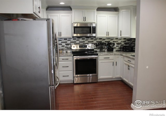 308 Prospect St, Fort Morgan, CO 80701 - kitchen featuring appliances with stainless steel finishes, dark wood finished floors, white cabinets, and recessed lighting