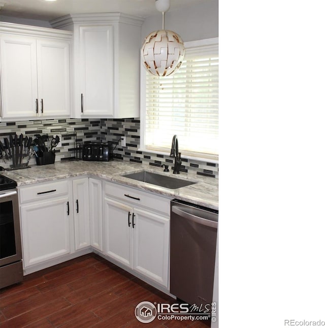 308 Prospect St, Fort Morgan, CO 80701 - kitchen with stainless steel appliances, tasteful backsplash, dark wood-style flooring, and white cabinetry