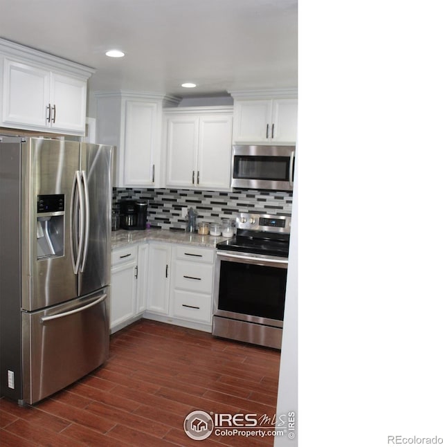 308 Prospect St, Fort Morgan, CO 80701 - kitchen featuring stainless steel appliances, white cabinetry, dark wood-style floors, backsplash, and light stone counters