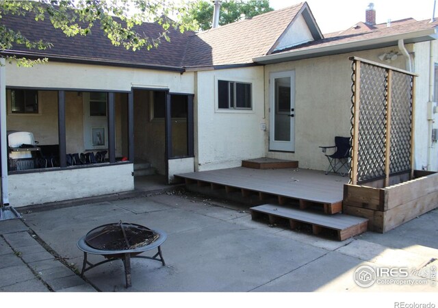 308 Prospect St, Fort Morgan, CO 80701 - rear view of property with a fire pit, roof with shingles, a deck, and stucco siding