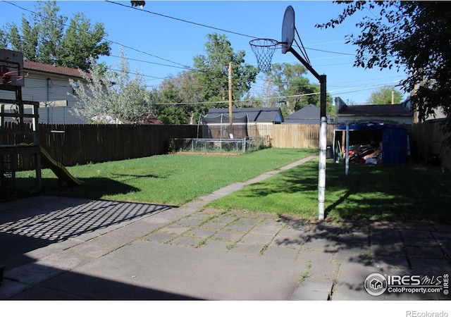 308 Prospect St, Fort Morgan, CO 80701 - fenced backyard featuring a trampoline, a patio area, and a playground
